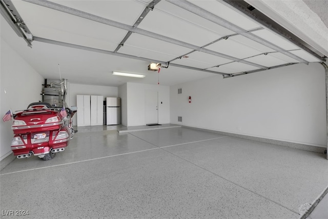 garage featuring a garage door opener and white refrigerator