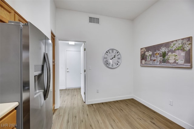 kitchen featuring stainless steel refrigerator with ice dispenser and light hardwood / wood-style flooring