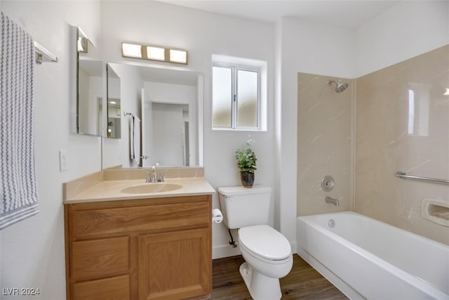 full bathroom with hardwood / wood-style floors, vanity, tiled shower / bath combo, and toilet