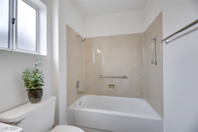 bathroom featuring tiled shower / bath and toilet