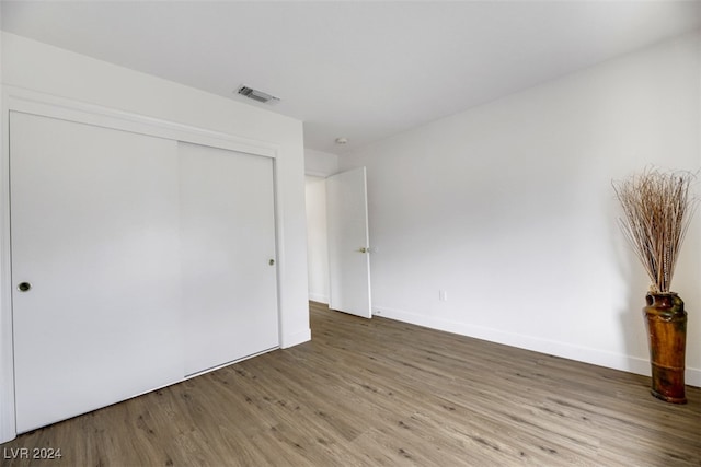 unfurnished bedroom featuring hardwood / wood-style floors and a closet