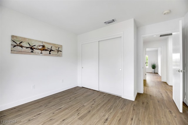 unfurnished bedroom with hardwood / wood-style flooring and a closet