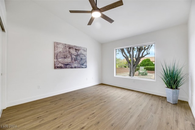 spare room featuring ceiling fan, lofted ceiling, and light wood-type flooring