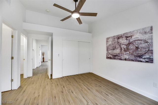 unfurnished bedroom with ceiling fan, a closet, and light hardwood / wood-style flooring