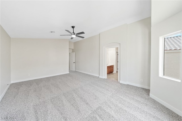 carpeted spare room with ceiling fan and lofted ceiling