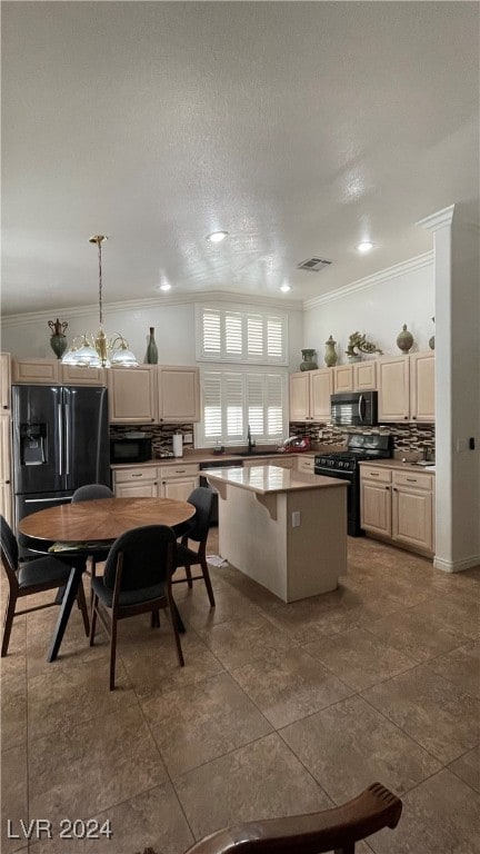 kitchen with a textured ceiling, crown molding, black appliances, decorative light fixtures, and a kitchen island