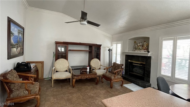 sitting room featuring a tile fireplace, ceiling fan, vaulted ceiling, and ornamental molding