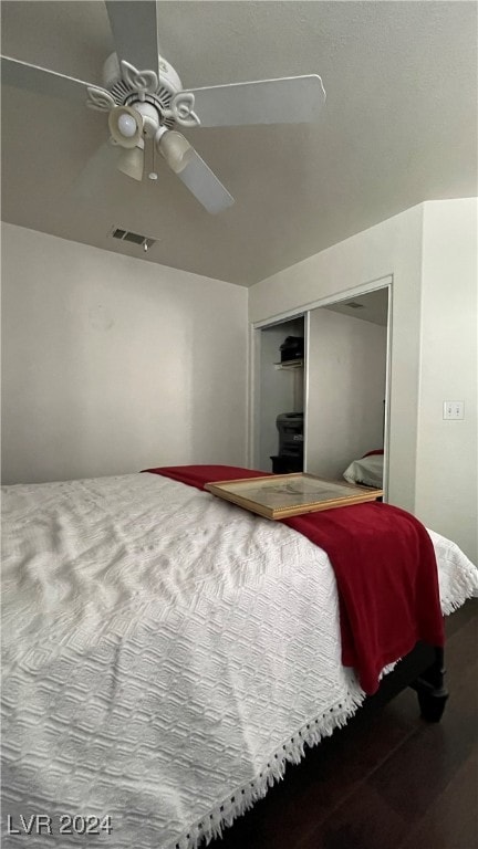 bedroom with ceiling fan, wood-type flooring, and a closet