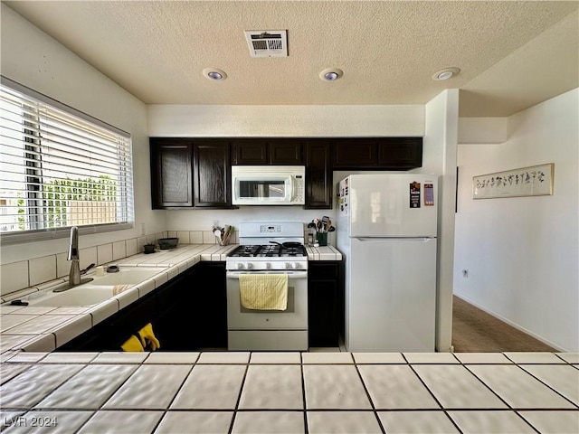 2153 Camel Mesa Dr, Laughlin, NV 89029 - kitchen with white appliances, tile counters, a textured ceiling, carpet flooring, and recessed lighting