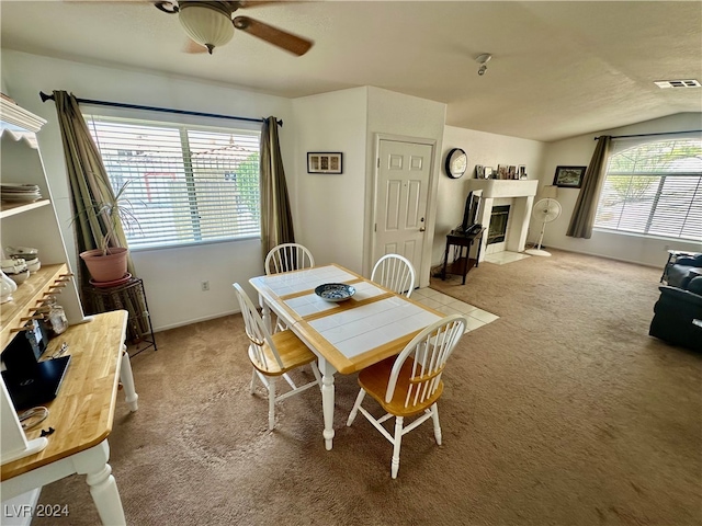 carpeted dining room featuring ceiling fan and lofted ceiling