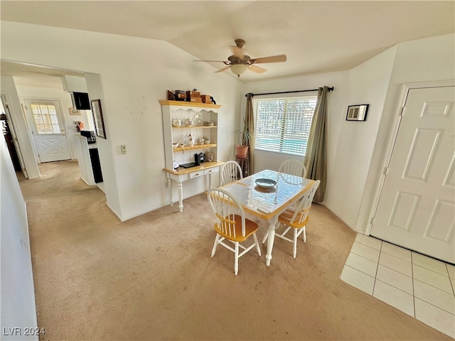 dining space with ceiling fan, light carpet, and vaulted ceiling