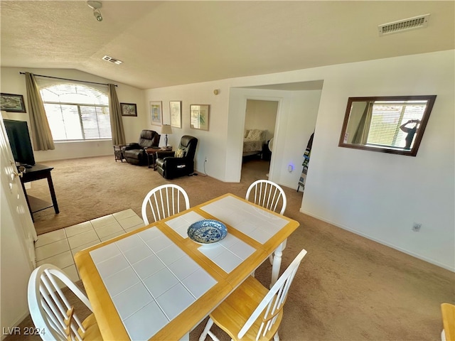 carpeted dining space featuring plenty of natural light and lofted ceiling