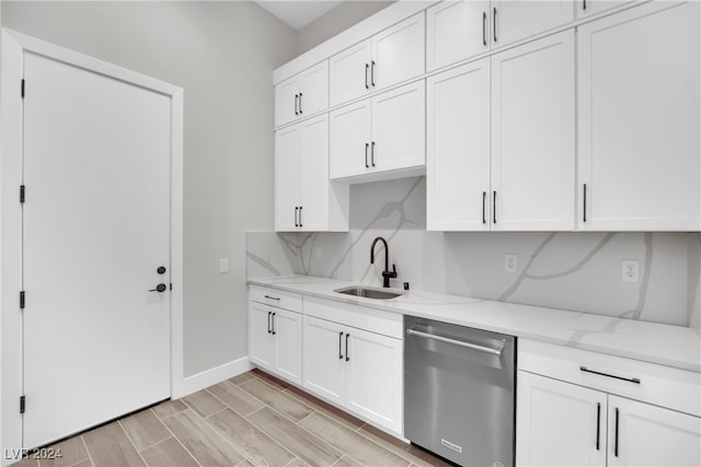 kitchen with dishwasher, sink, light stone countertops, light wood-type flooring, and white cabinetry