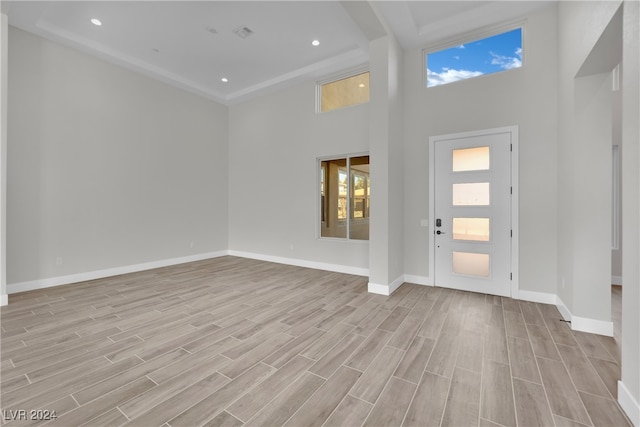 foyer entrance with light wood-type flooring and a high ceiling