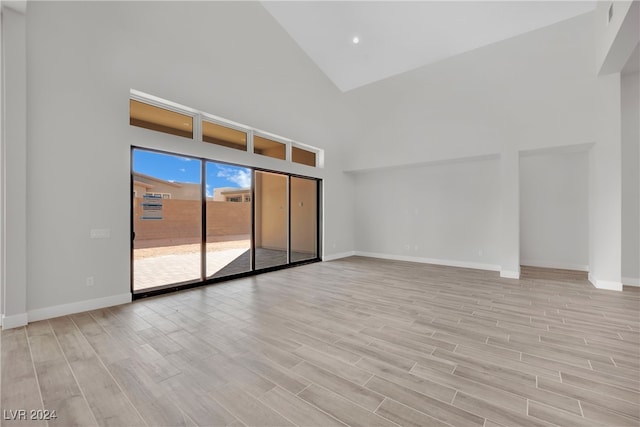 unfurnished living room featuring light hardwood / wood-style floors and high vaulted ceiling