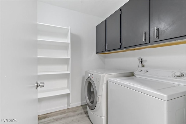 washroom with cabinets, washing machine and dryer, and light wood-type flooring