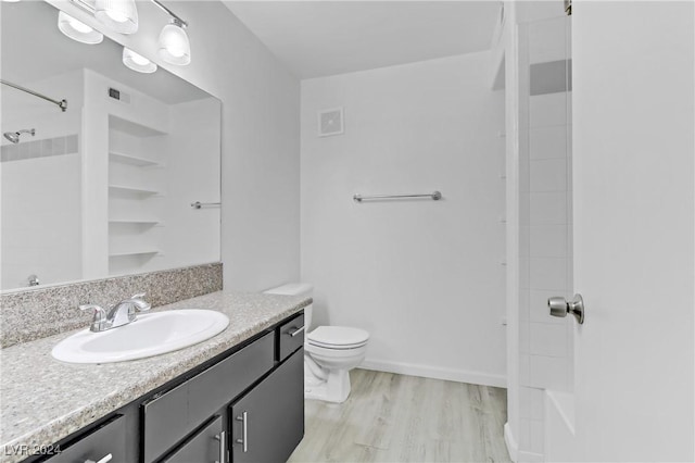 bathroom featuring walk in shower, vanity, toilet, and wood-type flooring