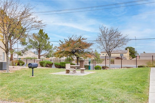 view of yard with central AC and a patio