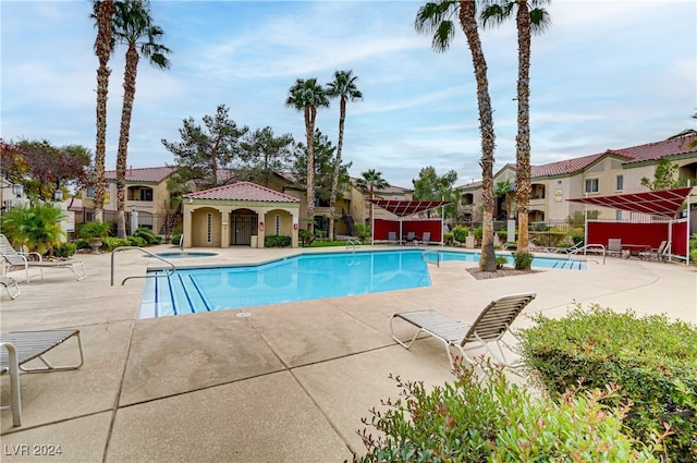 view of swimming pool featuring a hot tub and a patio area