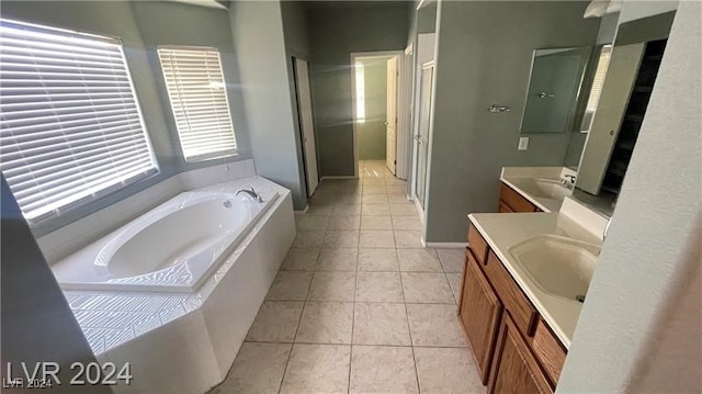 bathroom featuring tile patterned flooring, vanity, and tiled bath