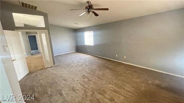 interior space featuring dark carpet and ceiling fan