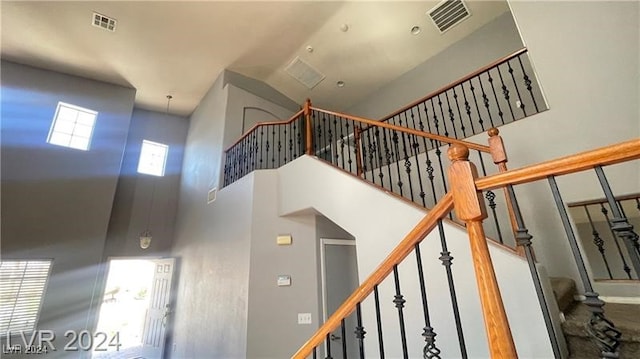 staircase featuring a high ceiling