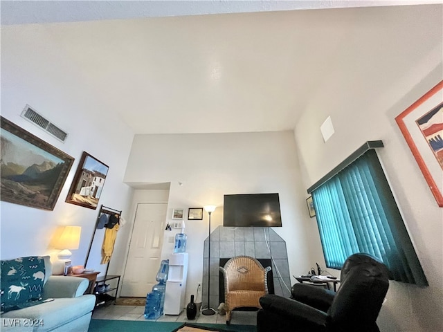 living room featuring a towering ceiling and a fireplace