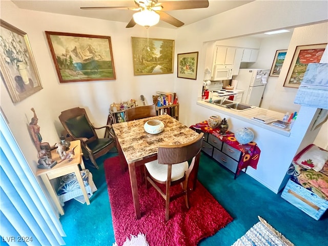 carpeted dining space with ceiling fan