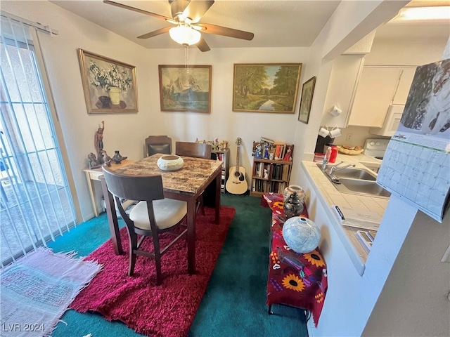 dining room featuring carpet floors, ceiling fan, and sink