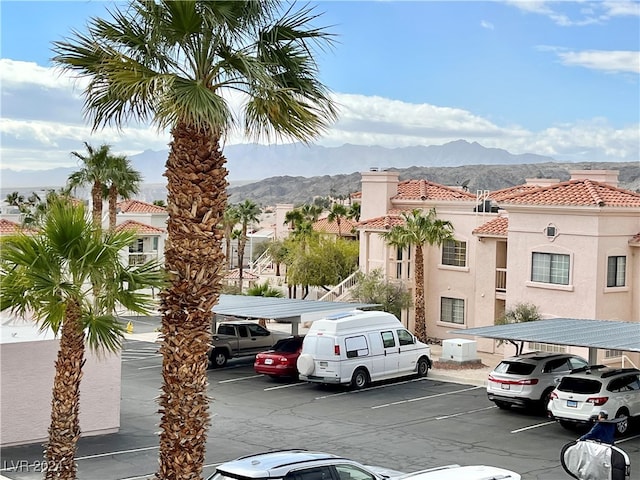 view of parking / parking lot featuring a carport and a mountain view