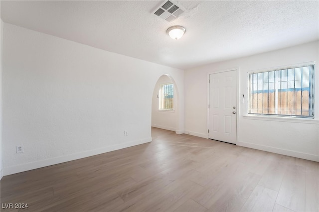 interior space with a healthy amount of sunlight, light hardwood / wood-style floors, and a textured ceiling