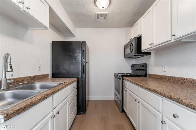 kitchen with white cabinetry, sink, light hardwood / wood-style flooring, a textured ceiling, and black appliances