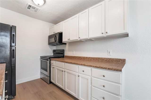 kitchen featuring white cabinets, a textured ceiling, light hardwood / wood-style floors, and black appliances