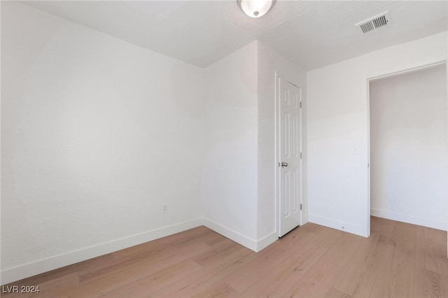 unfurnished bedroom featuring light wood-type flooring and a closet