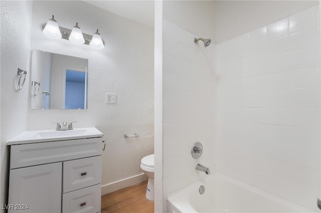 full bathroom with vanity, hardwood / wood-style flooring, toilet, and tiled shower / bath