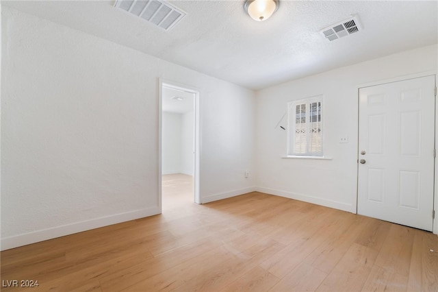 empty room featuring light hardwood / wood-style floors and a textured ceiling