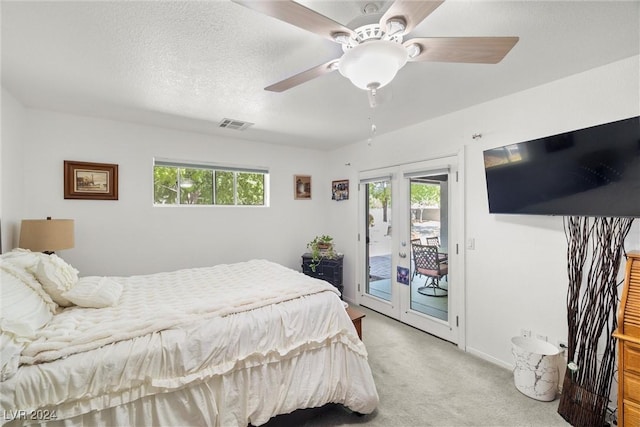 carpeted bedroom with multiple windows, ceiling fan, access to exterior, and a textured ceiling