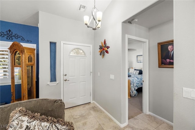 foyer entrance with light tile patterned flooring and a chandelier