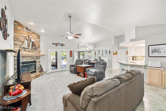 living room with french doors, high vaulted ceiling, a stone fireplace, and sink