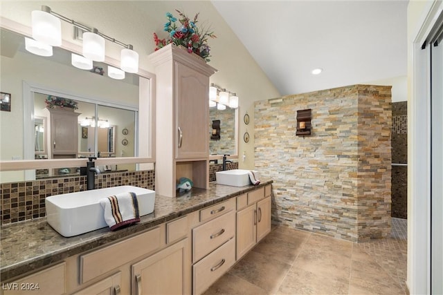 bathroom featuring tasteful backsplash, lofted ceiling, vanity, and a shower