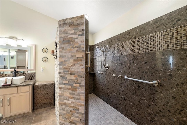 bathroom featuring tile patterned floors, vanity, decorative backsplash, and a tile shower