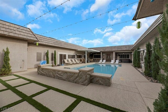 view of swimming pool featuring a patio and a jacuzzi