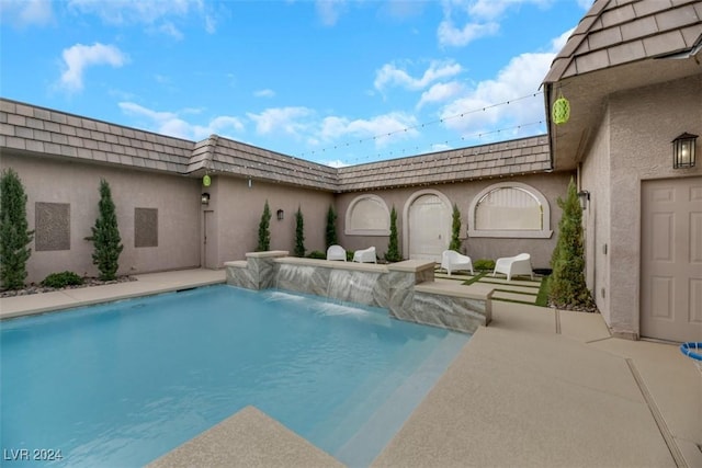 view of swimming pool featuring pool water feature and a patio area