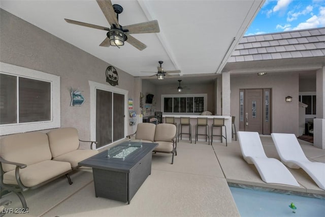 view of patio / terrace with ceiling fan, an outdoor bar, and an outdoor living space with a fire pit