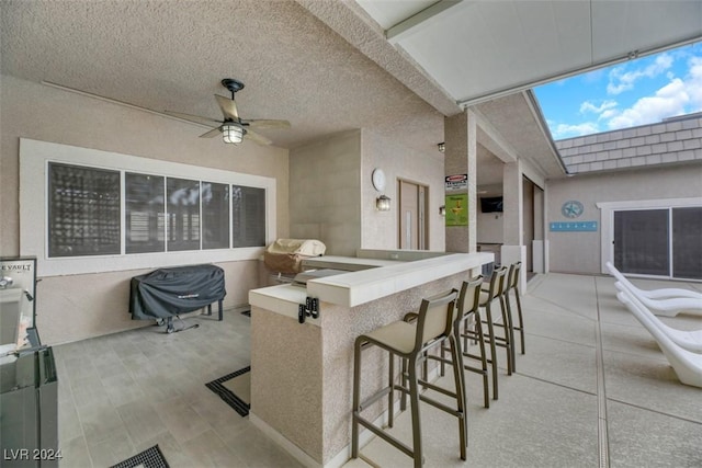 view of patio with outdoor wet bar and a ceiling fan