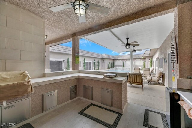 view of patio featuring area for grilling and ceiling fan