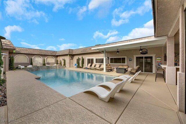 view of pool featuring an outdoor living space, ceiling fan, and a patio area