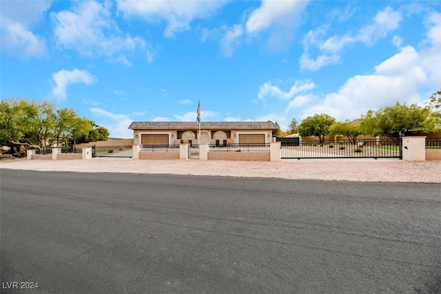 view of front facade with a fenced front yard, a garage, and a gate