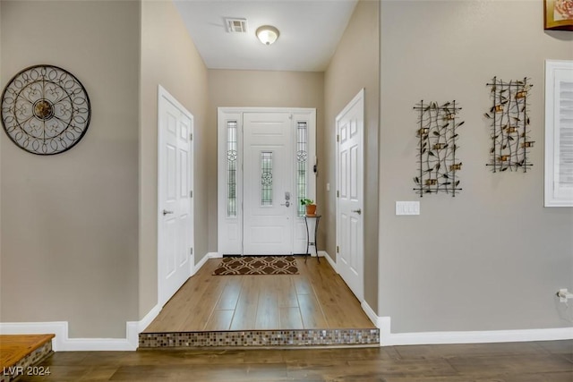 entryway featuring visible vents, baseboards, and wood finished floors