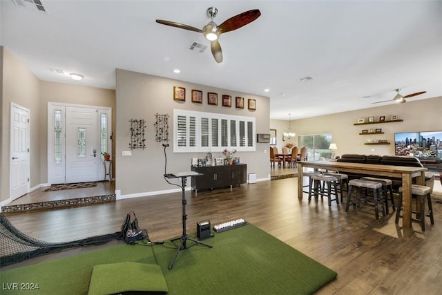 living room with dark hardwood / wood-style floors and ceiling fan with notable chandelier